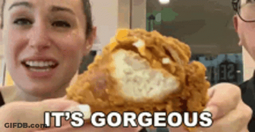 A Woman Is Holding A Piece Of Fried Chicken With The Words It 'S Gorgeous Behind Her GIF