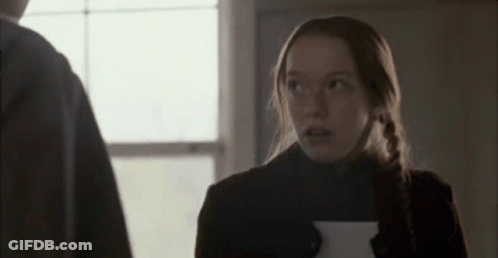 A Woman Is Holding A Piece Of Paper And Looking Up At A Man . GIF