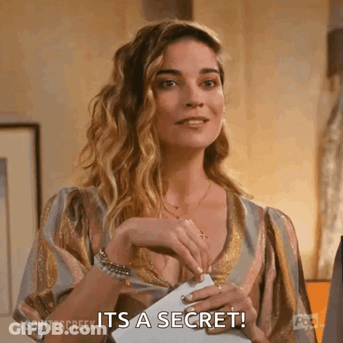 A Woman Is Holding A Piece Of Paper In Her Hand And Saying It 'S A Secret . GIF