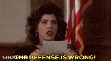 A Woman Is Holding A Piece Of Paper In Her Hand And Says The Defense Is Wrong . GIF
