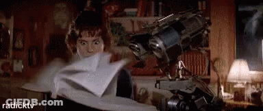 A Woman Is Holding A Piece Of Paper In Her Hand In Front Of A Robot . GIF
