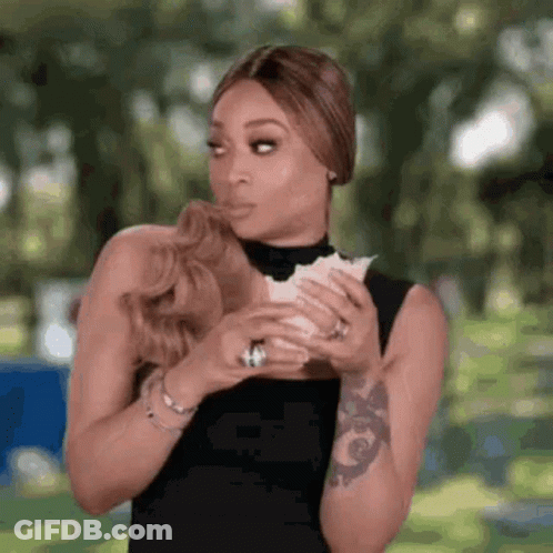 A Woman Is Holding A Piece Of Paper In Her Hands . GIF