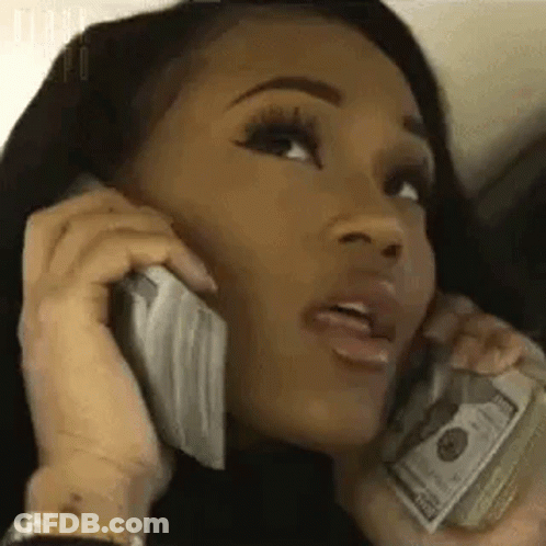 A Woman Is Holding A Pile Of Money And Talking On A Cell Phone . GIF