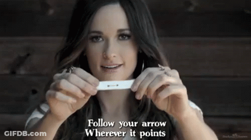 A Woman Is Holding A Pregnancy Test In Her Hands With The Words Follow Your Arrow Wherever It Points . GIF