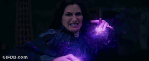 A Woman Is Holding A Purple Object In Her Hand And Making A Funny Face . GIF