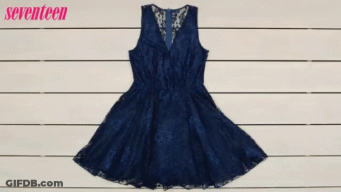 A Woman Is Holding A Purse In Front Of A Blue Dress GIF