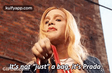 A Woman Is Holding A Red Bag And Saying `` It 'S Not Just A Bag , It 'S Prada . GIF