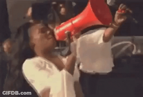 A Woman Is Holding A Red Megaphone In Her Mouth And Shouting Into It . GIF