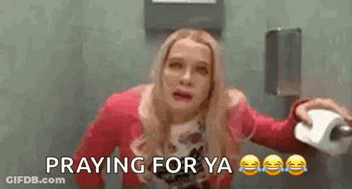 A Woman Is Holding A Roll Of Toilet Paper In A Bathroom And Praying For Ya . GIF