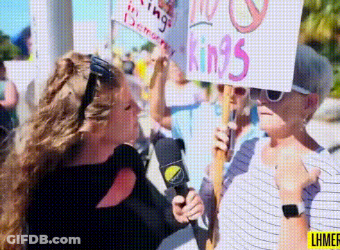 A Woman Is Holding A Sign That Says " No Kings " GIF