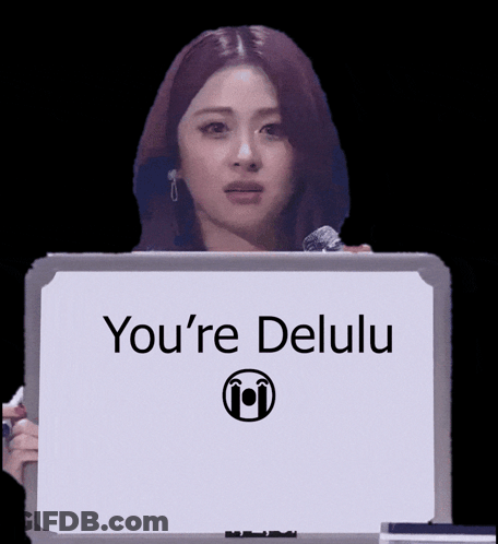 A Woman Is Holding A Sign That Says You 'Re Delulu GIF