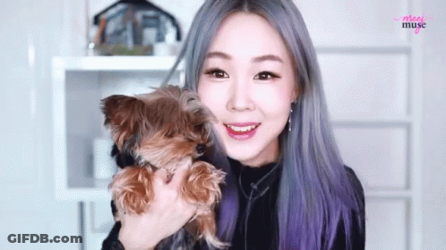 A Woman Is Holding A Small Brown Dog In Her Arms And The Word Muse Is On The Bottom GIF