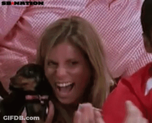 A Woman Is Holding A Small Dog And Laughing With A Sb Nation Logo In The Background GIF