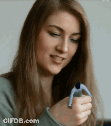 A Woman Is Holding A Small Man In Her Hands GIF