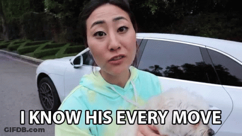 A Woman Is Holding A Small White Dog In Front Of A White Car And Says I Know His Every Move GIF