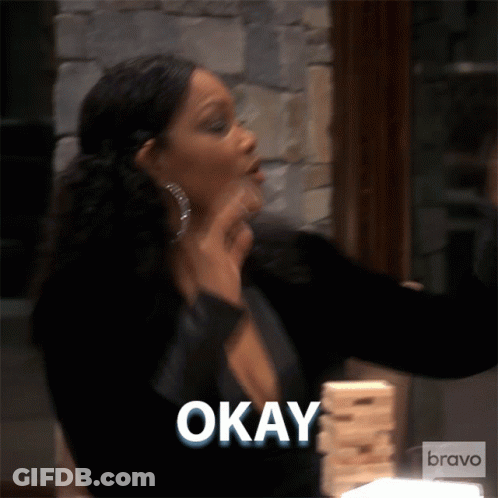 A Woman Is Holding A Stack Of Jenga Blocks And Says " Okay " GIF