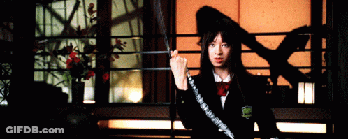 A Woman Is Holding A Sword In Front Of A Window GIF