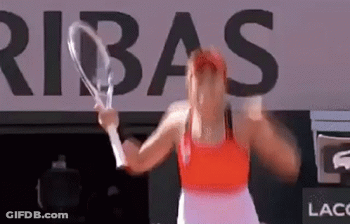 A Woman Is Holding A Tennis Racket In Front Of A Large Sign That Says Ribas . GIF