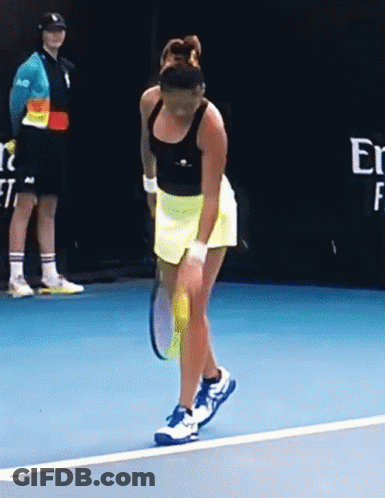 A Woman Is Holding A Tennis Racket On A Blue Court GIF