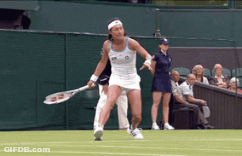 A Woman Is Holding A Tennis Racket On A Tennis Court GIF