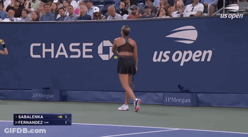 A Woman Is Holding A Tennis Racquet In Front Of A Scoreboard That Says 98 Mph Serve Speed GIF