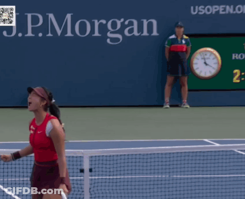 A Woman Is Holding A Tennis Racquet In Front Of A Sign For The Us Open GIF