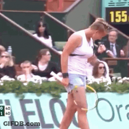 A Woman Is Holding A Tennis Racquet In Front Of A Sign That Says Lelo Ora GIF