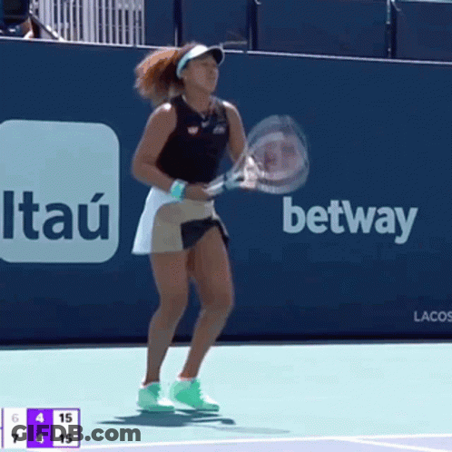 A Woman Is Holding A Tennis Racquet In Front Of An Advertisement For Itaú GIF