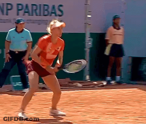 A Woman Is Holding A Tennis Racquet On A Court In Front Of A Sign That Says Np Paribas GIF