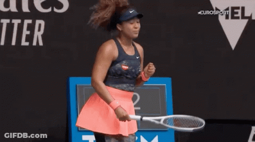 A Woman Is Holding A Tennis Racquet On A Tennis Court And Celebrating . GIF