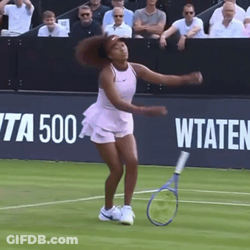 A Woman Is Holding A Tennis Racquet On A Tennis Court In Front Of A Banner That Says Wta 500 GIF