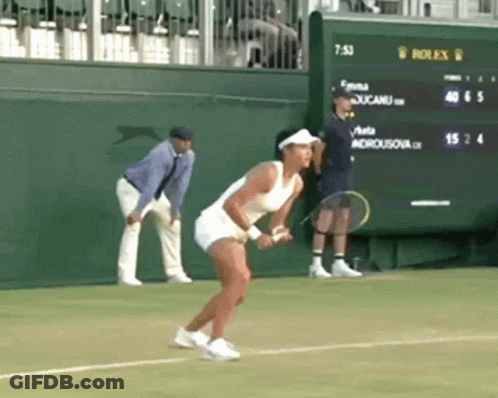 A Woman Is Holding A Tennis Racquet On A Tennis Court In Front Of A Scoreboard That Says Rolex On It GIF