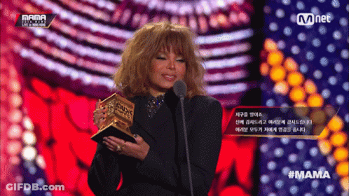 A Woman Is Holding A Trophy And Speaking Into A Microphone At A Mama Event GIF