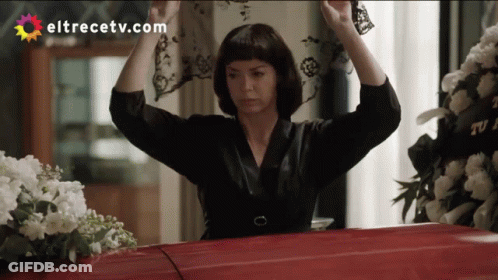 A Woman Is Holding A Veil Over A Red Coffin With Eltrecetv.com Written On The Bottom GIF