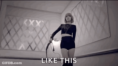 A Woman Is Holding A Whip In A Black And White Photo And The Words `` Like This '' Are Next To Her . GIF
