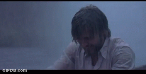 A Woman Is Holding A White Cloth Over Her Head In The Rain . GIF
