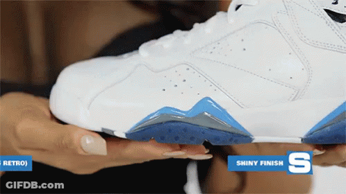 A Woman Is Holding A White Shoe With A Shiny Finish On The Bottom GIF