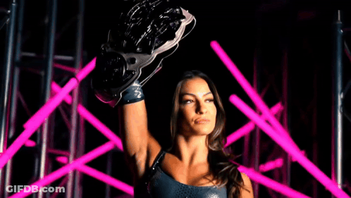 A Woman Is Holding A Wrestling Glove Over Her Head With The Words Evolve Champion Behind Her GIF