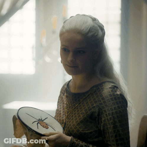 A Woman Is Holding An Embroidery Hoop With A Butterfly On It GIF