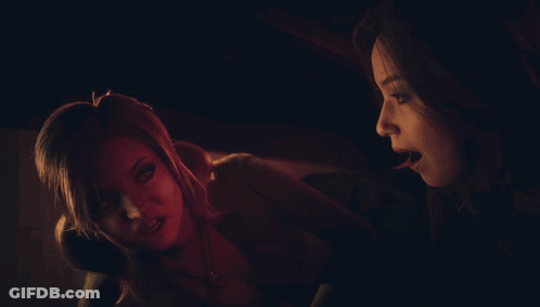 A Woman Is Holding Another Woman 'S Hand While They Look At Something In A Dark Room GIF
