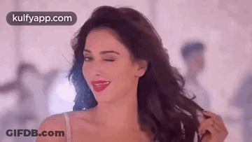 A Woman Is Holding Her Hair And Smiling While Wearing A Bra . GIF