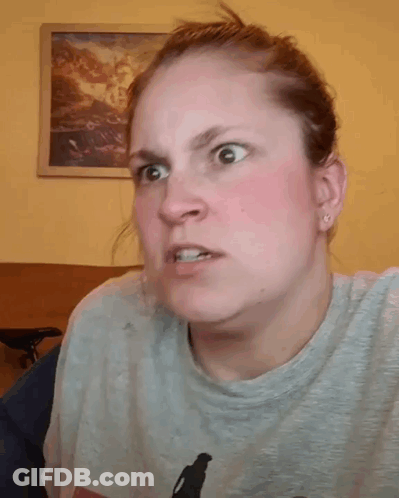A Woman Is Holding Her Hair In A Ponytail While Wearing A Gray Shirt . GIF
