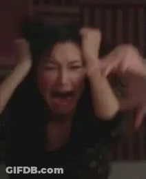 A Woman Is Holding Her Head With Her Hands While Crying . GIF