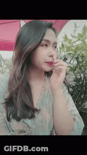 A Woman Is Holding Her Nose While Wearing Lipstick GIF