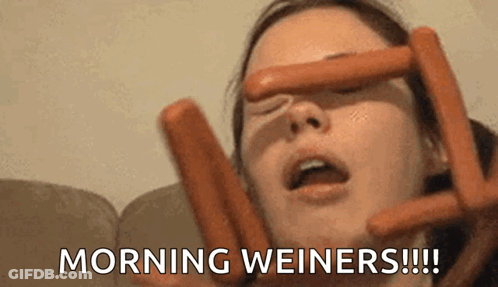 A Woman Is Holding Two Hot Dogs In Front Of Her Face And Says Morning Weiners GIF
