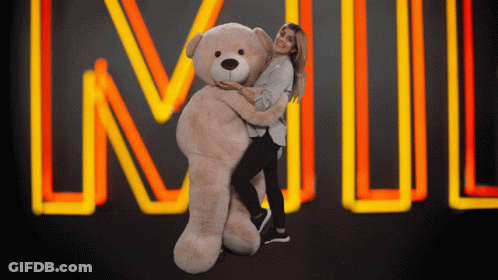A Woman Is Hugging A Giant Teddy Bear In Front Of A Neon Sign That Says Lnwl GIF
