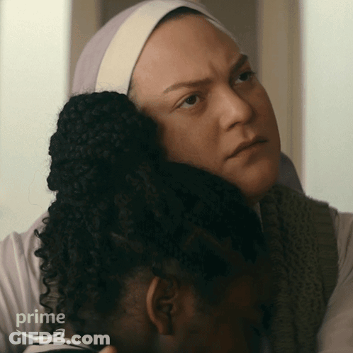A Woman Is Hugging Another Woman Who Is Wearing A Headband That Says Prime GIF