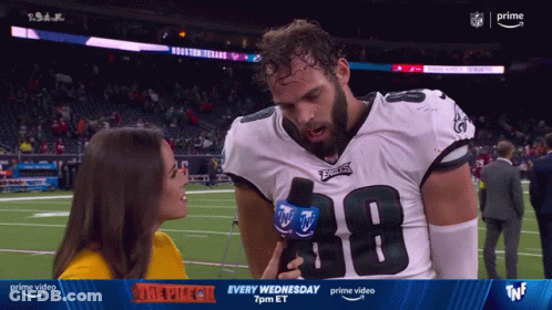 A Woman Is Interviewing A Football Player Wearing A Number 38 Jersey GIF