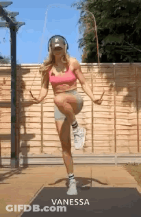 A Woman Is Jumping A Jump Rope While Wearing Headphones And A Hat . GIF