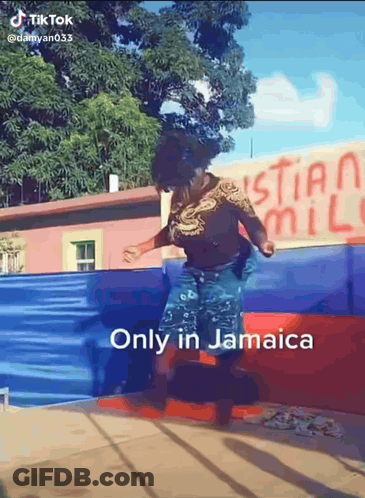 A Woman Is Jumping In The Air In Front Of A Sign That Says Christian Mill GIF